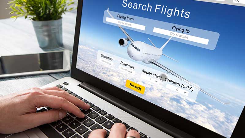 Homem a pesquisar viagens de avião no portátil